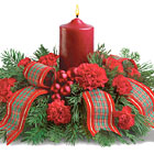 Chase away the winter blues with this compact pillar candle centerpiece featuring fluffy red carnations, fresh winter greens, miniature ornament balls, and festive holiday ribbon. A classic gift and colorful holiday accent. Available after Thanksgiving till Christmas. USA and Canada florist delivery.